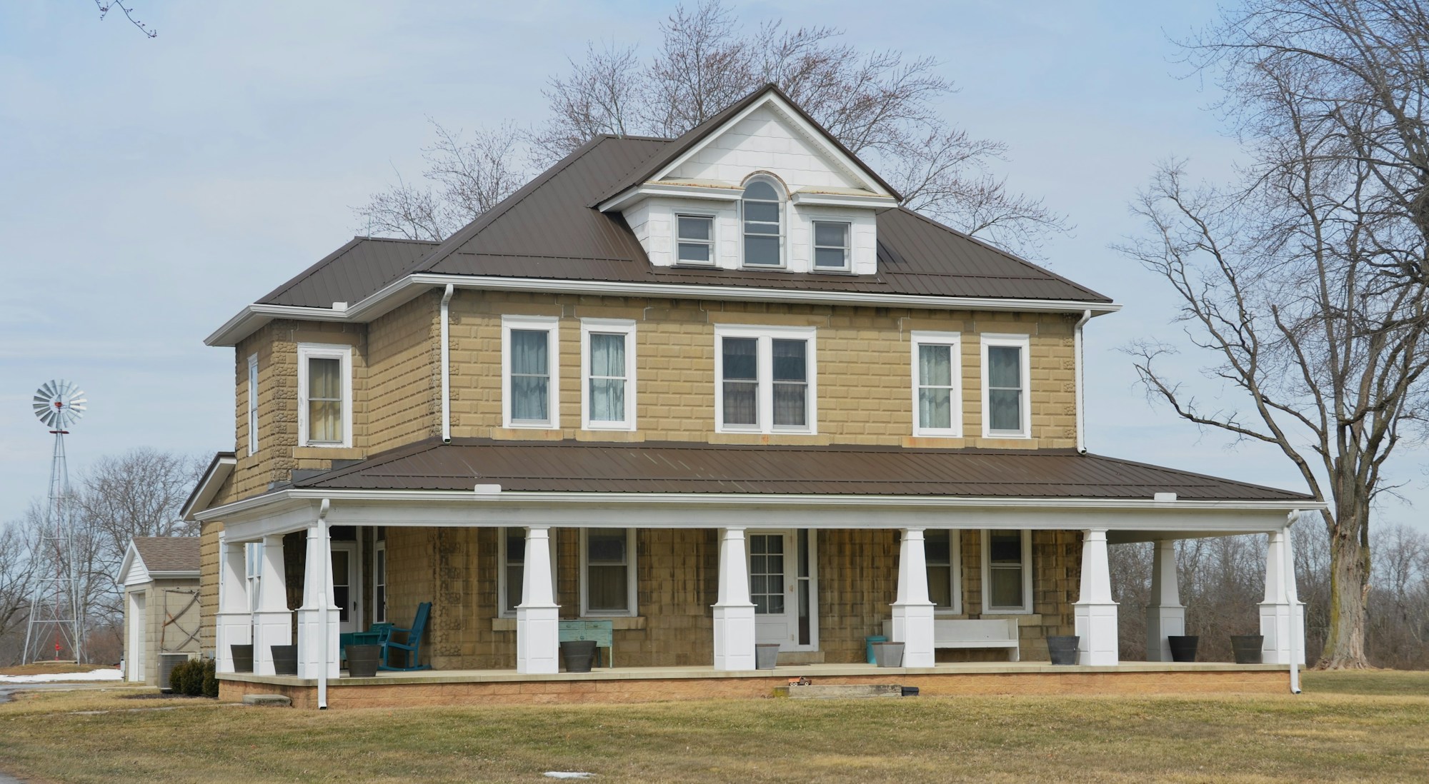 A large brown house sitting in the middle of a field