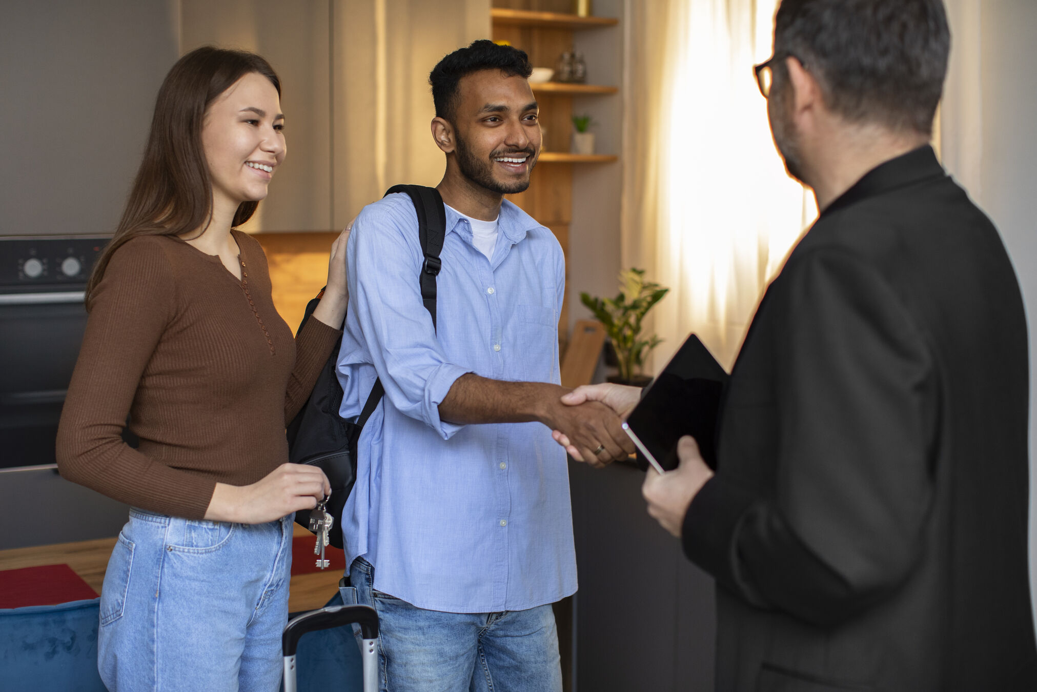 Agent greeting buyers at the door while referencing an open house checklist for agents